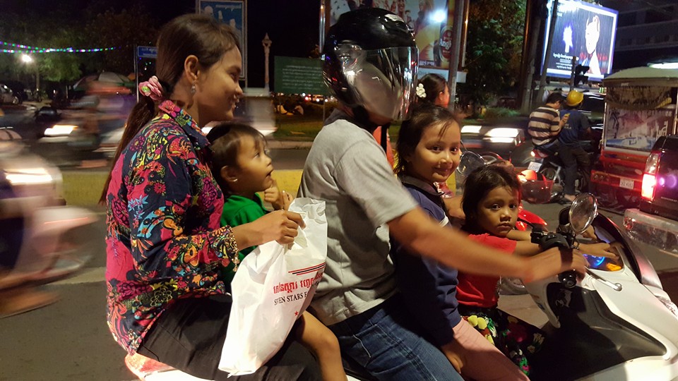 A family enjoys a motorbike travelling in late May 2016 in Phnom Penh and only the farther as helmet. (Photo: Im Sothearith) 